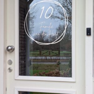 Voordeur met op het glas een opdruk van twee in elkaar overlopende getekende cirkels met in het midden de naam in sierlijk lettertype
