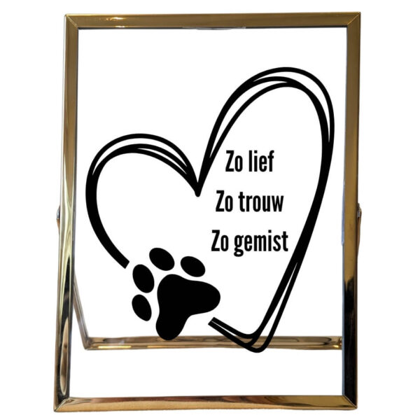 Een gouden fotolijst met een opdruk van een hart, welke onderbroken is door een pootafruk. In de hartje staat: zo lief, zo trouw, zo gemist.