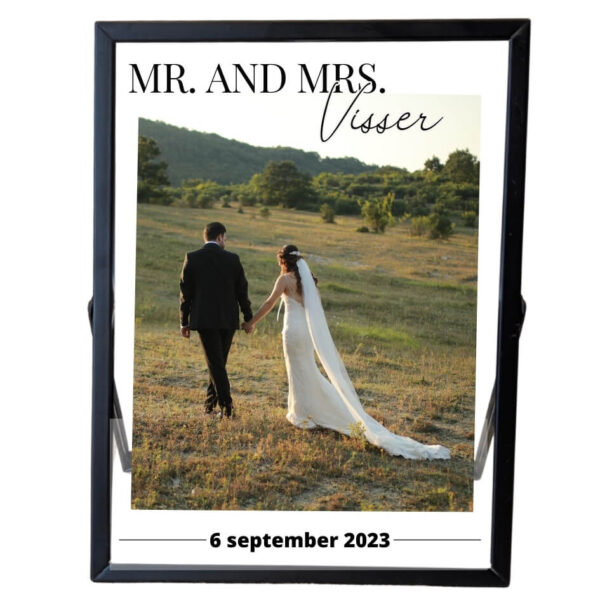 Een zwart fotolijstje met een trouwfoto. Boven de foto staat mr. and mrs. met sierlijk de achternaam. Onder de foto staat een datum.