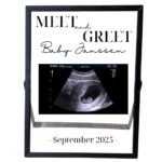 Een zwarte fotolijst met een echofoto en daarboven een opdruk van de tekst: meet and greet en eronder baby + achternaam en de maand + jaar.