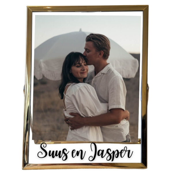 Een gouden fotolijst met daarin een foto van een verliefd stel met daaronder een opdruk van twee namen.