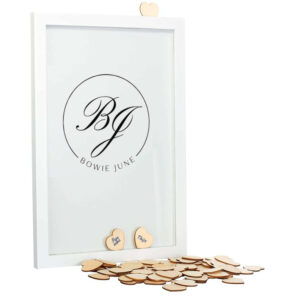 Een witte staande fotolijst met een zwarte opdruk van een cirkel met daarin sierlijke initialen en de volledige namen