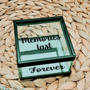 Vierkant glazen kistje met zwart frame en bovenop een opdruk: "memories last" en aan de voorkant de tekst: "forever"