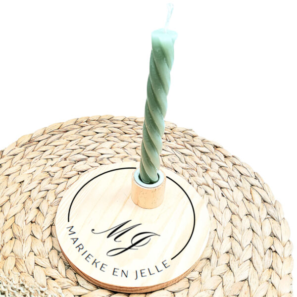 Ronde blanco houten kaarsenstandaard met een zwarte opdruk van een onderbroken cirkel met de namen met in het midden sierlijke intialen