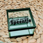 Glazen kistje met zwart frame en een opdruk van de tekst: jouw eerste speentje, waarvan "jouw eerste" in sierlijk lettertype.