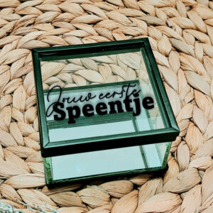 Glazen kistje met zwart frame en een opdruk van de tekst: jouw eerste speentje, waarvan "jouw eerste" in sierlijk lettertype.