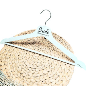 Een wit houten kleerhanger met daarop de bedrukking van de rol in sierlijke letters en daaronder de datum.