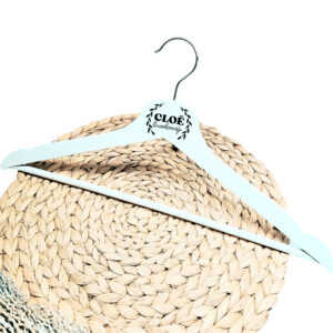 Een wit houten kleerhanger met daarop de bedrukking van de naam en in het klein de rol eronder, omcirkelt door sierlijke takjes.