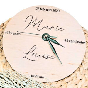 Een blanco houten ronde klok met zwarte wijzers en een opdruk van de naam in sierlijke letters met daaromheen de datum tijd lengte en gewicht