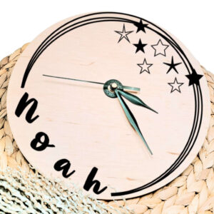 Een blanco houten ronde klok met zwarte wijzers en een opdruk van diverse speelse cirkels welke onderbroken worden door de naam en sterren.