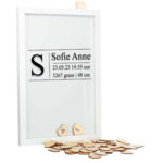 Een witte staande fotolijst met een zwarte opdruk van de beginletter, voornamen, datum, tijd, gewicht en lengte, geplaatst in kaders.