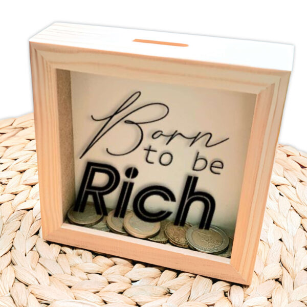 Een blanco houten vierkante spaarpot waarvan het glas bedrukt is met de tekst: Born to be rich, in verschillende lettertypes.
